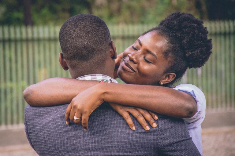 Woman Hugging a Man in Gray Suit Jacket