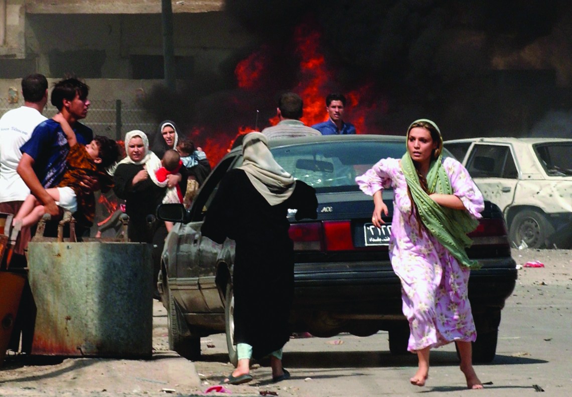 BAGHDAD, IRAQ - SEPTEMBER 30: Iraqi citizen's flee the scene after three explosions September 30, 2004 in Baghdad, Iraq. Three seperate explosions near a U.S. military convoy which was passing the opening ceremony for a sewage station killed at least 35 people and wounded more than 100 others in southern Baghdad according to Iraqi police. (Photo by Wathiq Khuzaie/Getty Images)