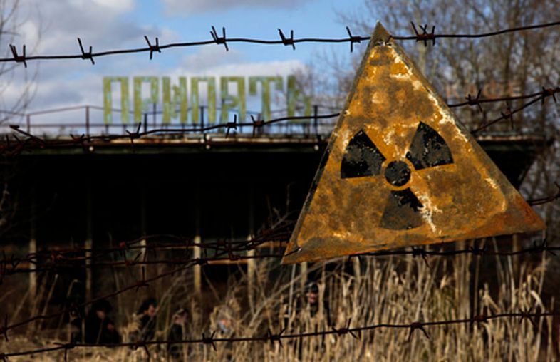 A radioactive sign hangs on barbed wire outside a café in Pripyat via wiki commons