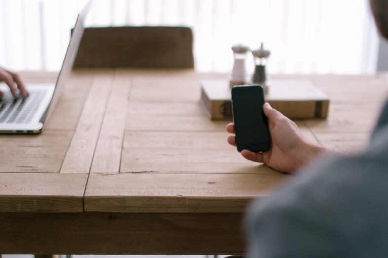 person-smartphone-office-table-large