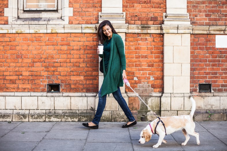 Happy woman walking with dog in early Sunday morning in London, Notting Hill.