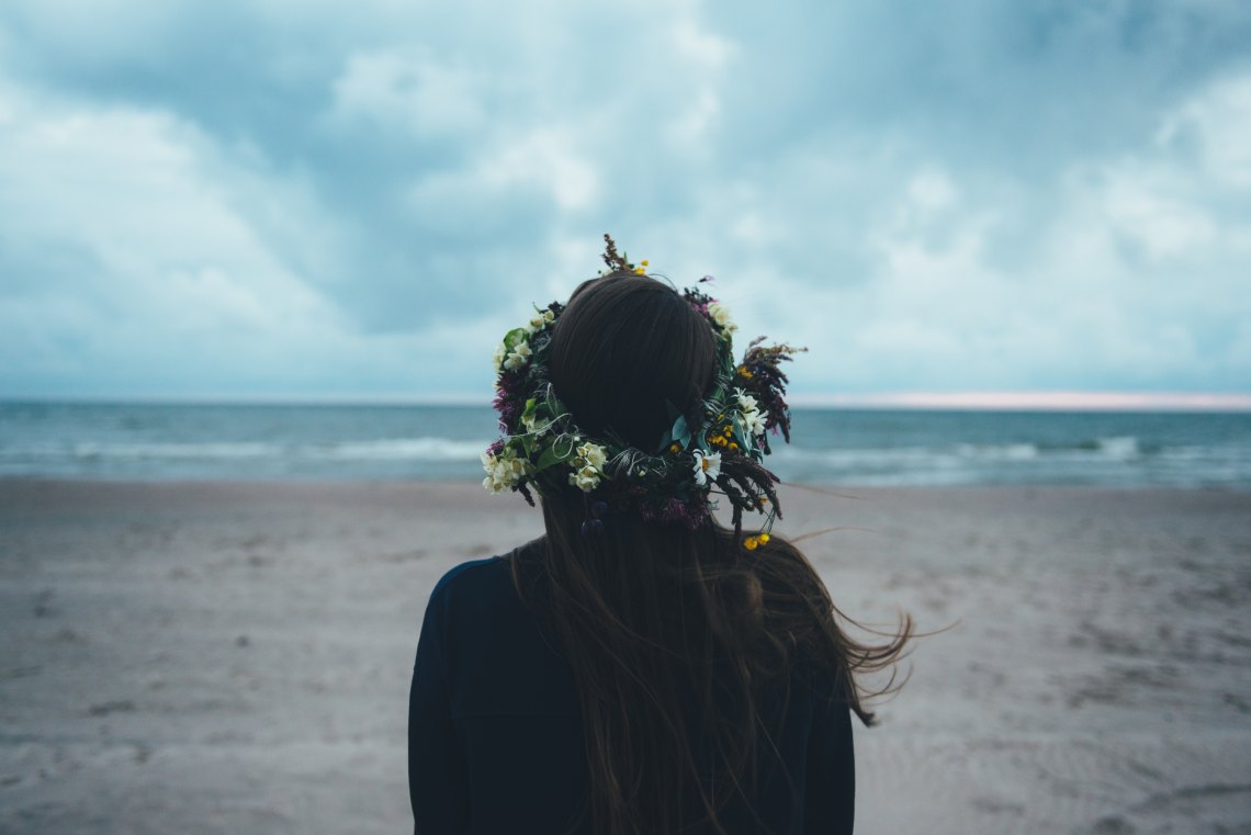 Woman with flower crown by beach