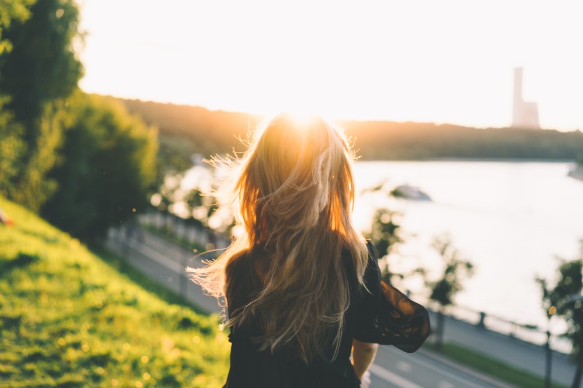 Blonde woman in front of sun