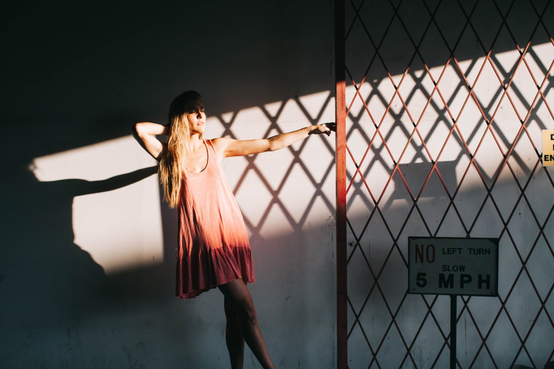 Girl in pink dress in front of shadows