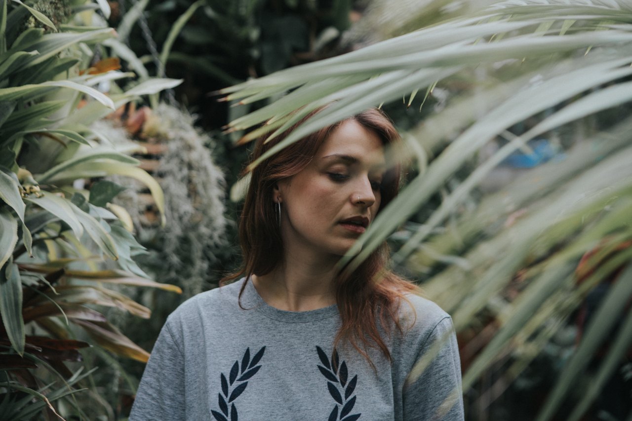 Redhead woman surrounded by greenery