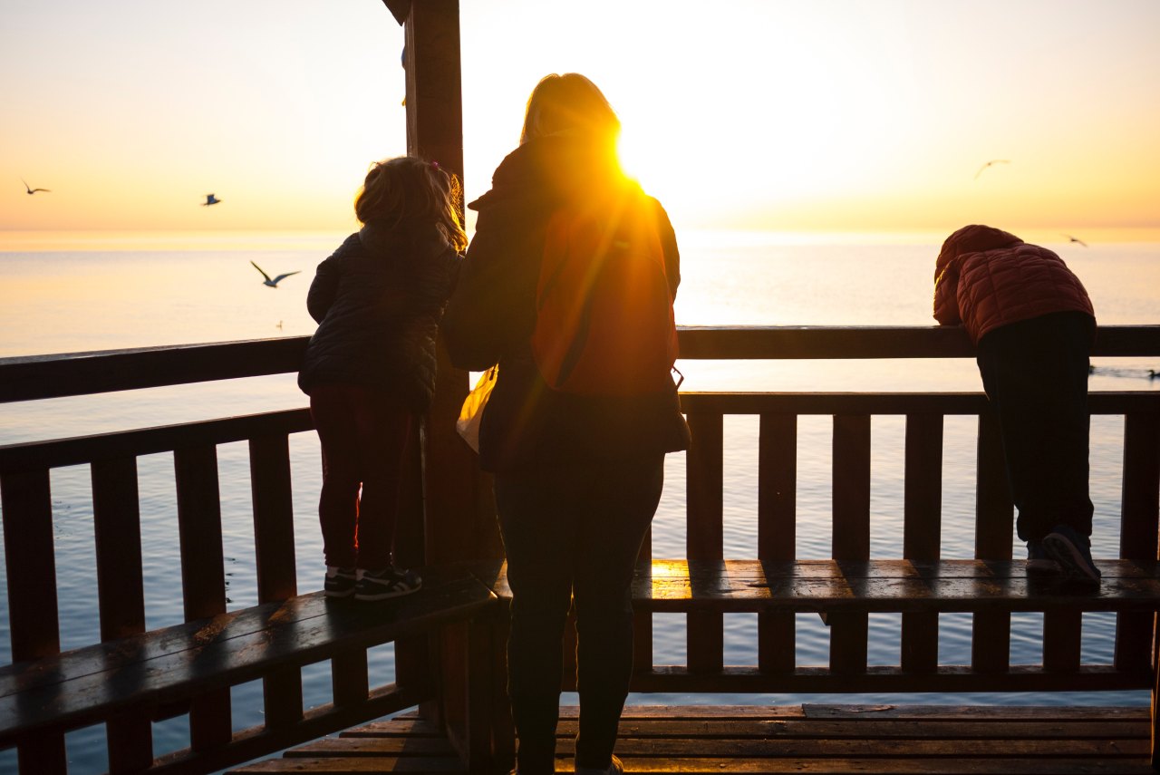 Mom looking at ocean with kids