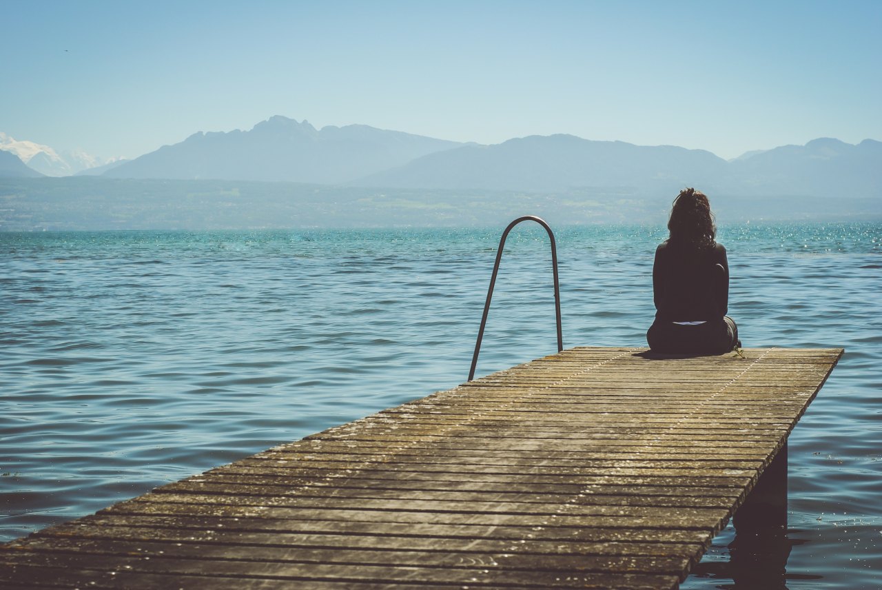 Girl sitting in front of lake