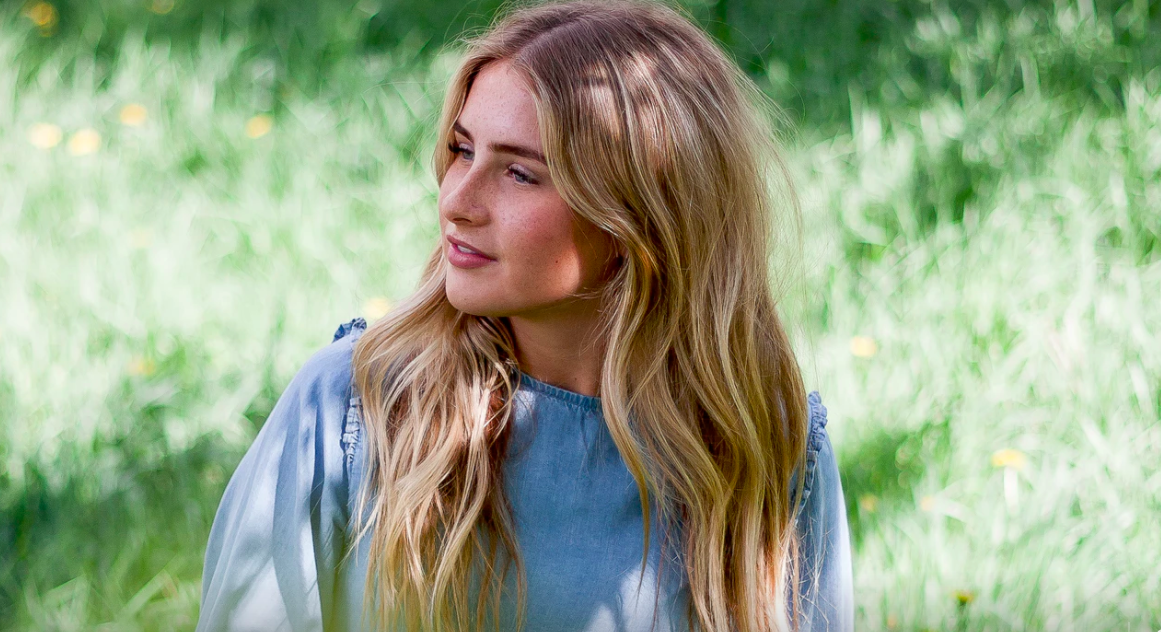 Blonde young woman in field