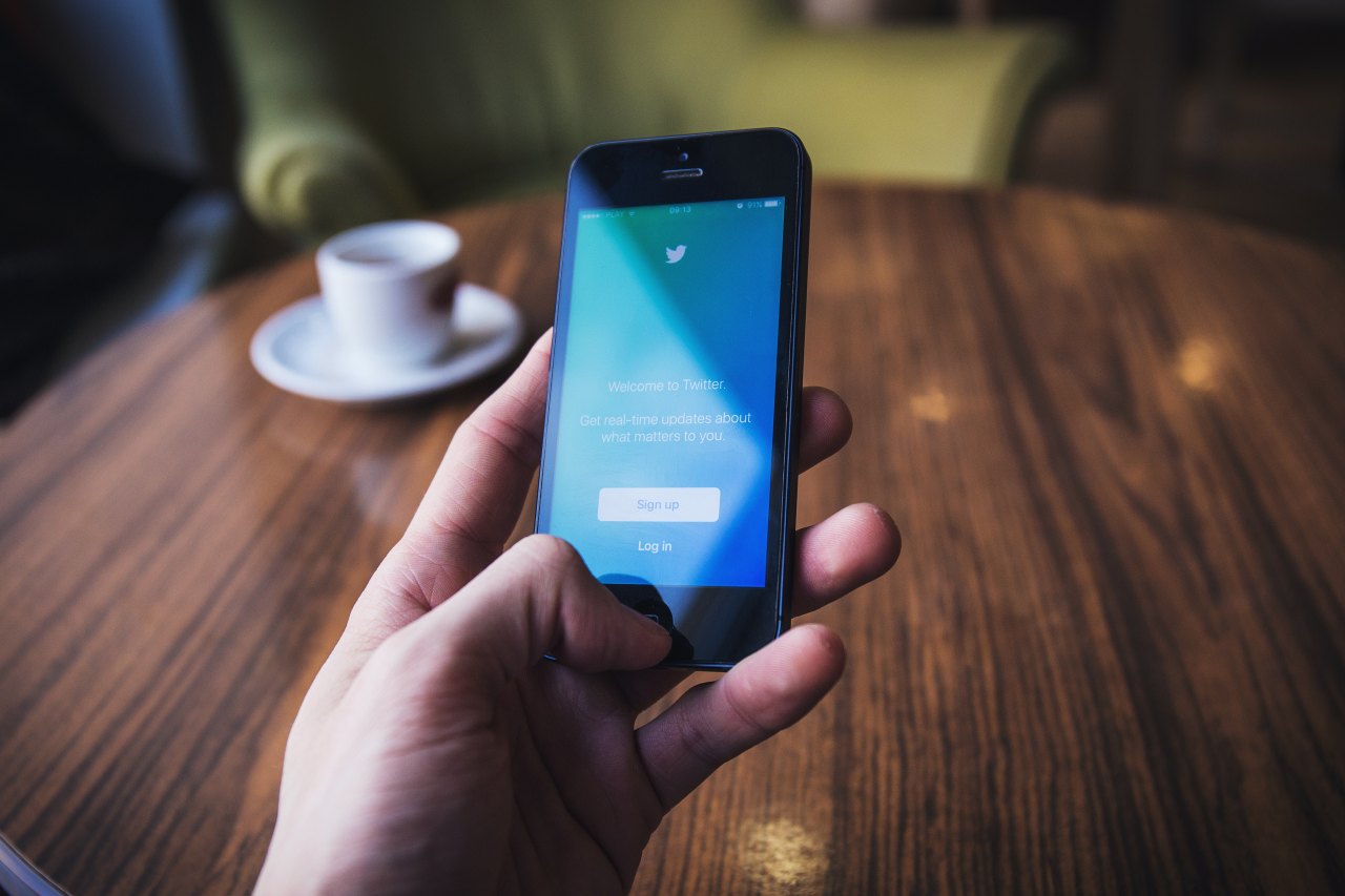 man using twitter while at a coffee shop