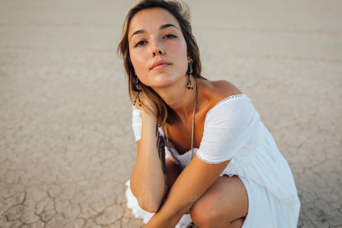 Woman in white dress with brown background