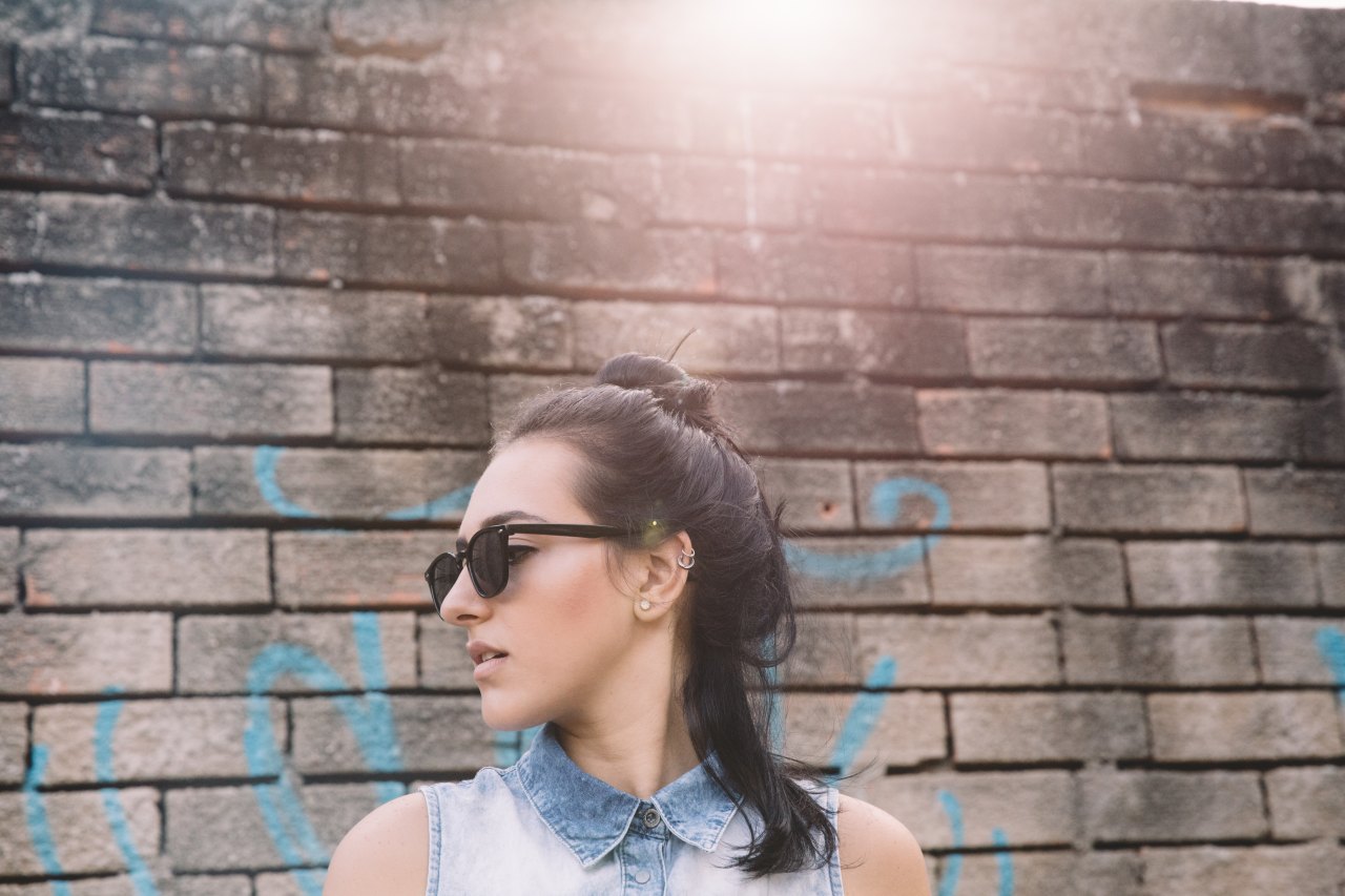 woman standing in front of brick wall