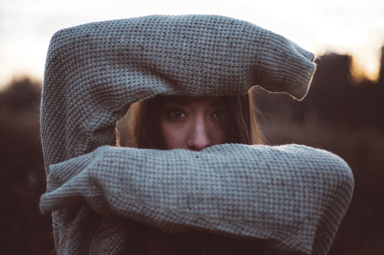 woman with arms over face