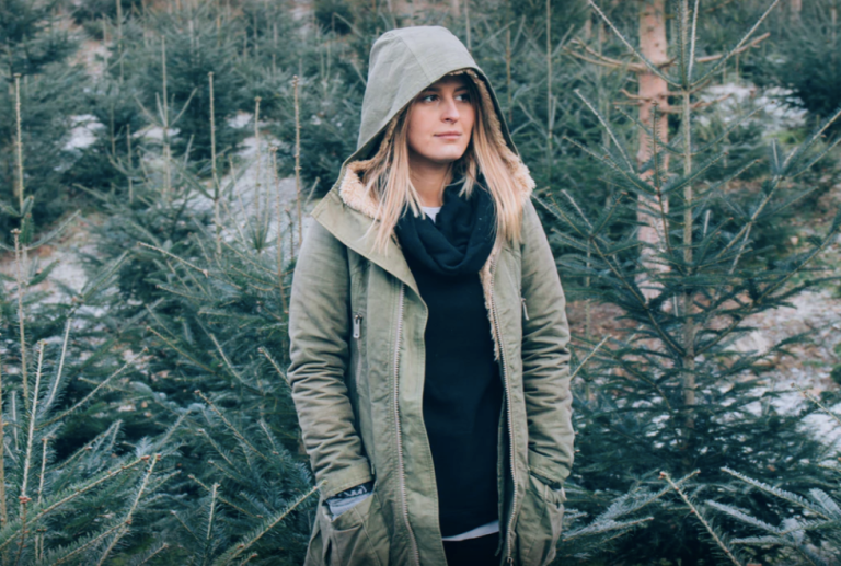 Girl standing amongst fir trees