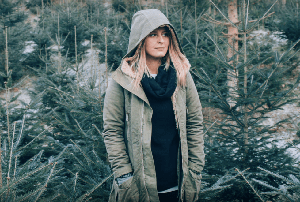 Girl standing amongst fir trees