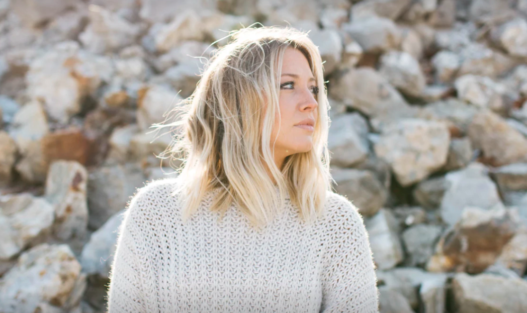 Blonde woman in front of rocks