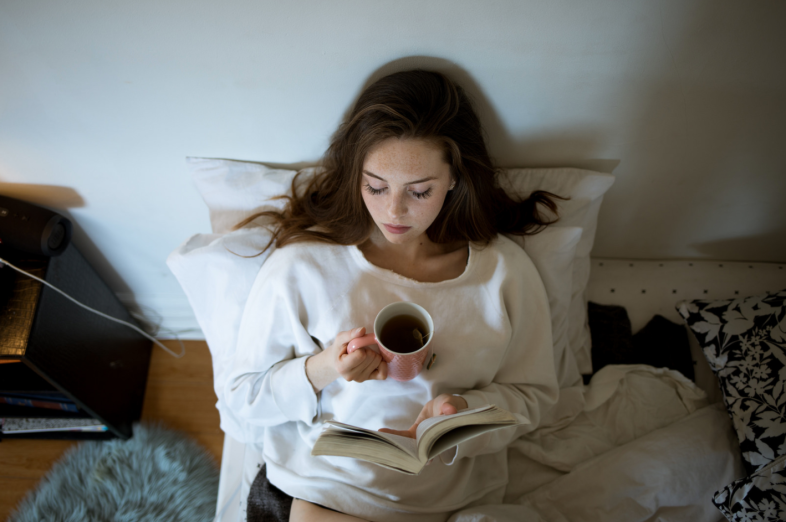 Shy girl reads a book alone in her room