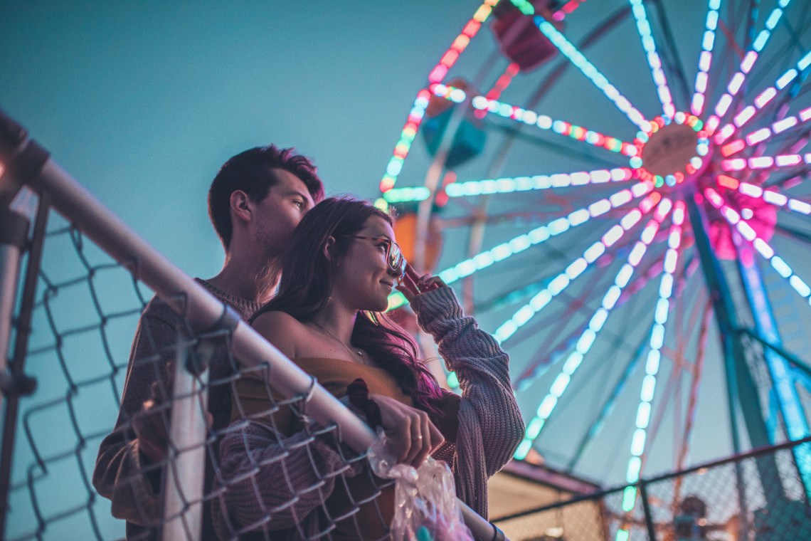 couple at a fair, couple by ferris wheel, happy couple, trusting the unknown