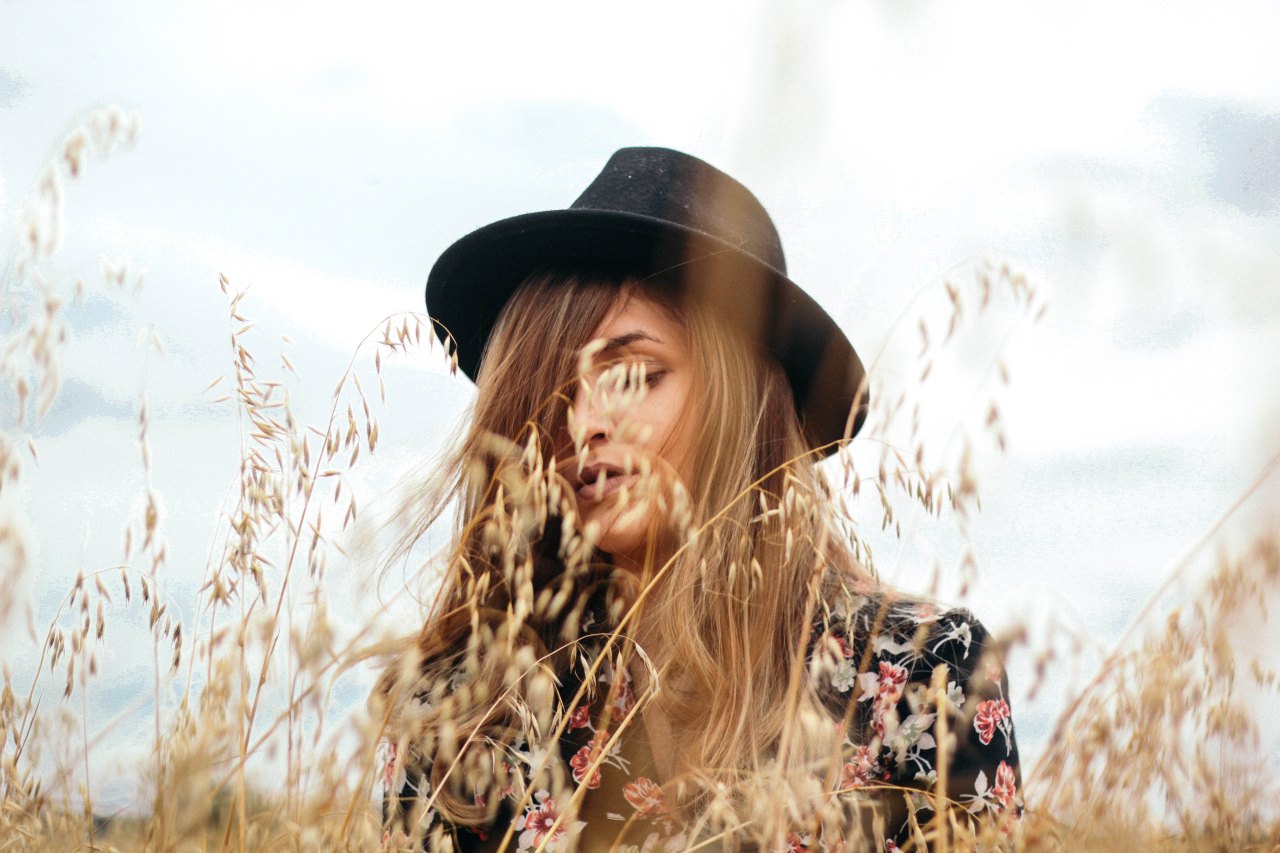 Woman in fedora in field