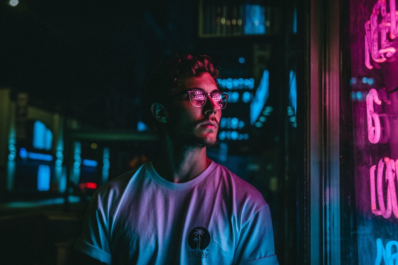 man in lights looking at store sign, somber man, addiction quotes, overcoming addiction, addiction recovery