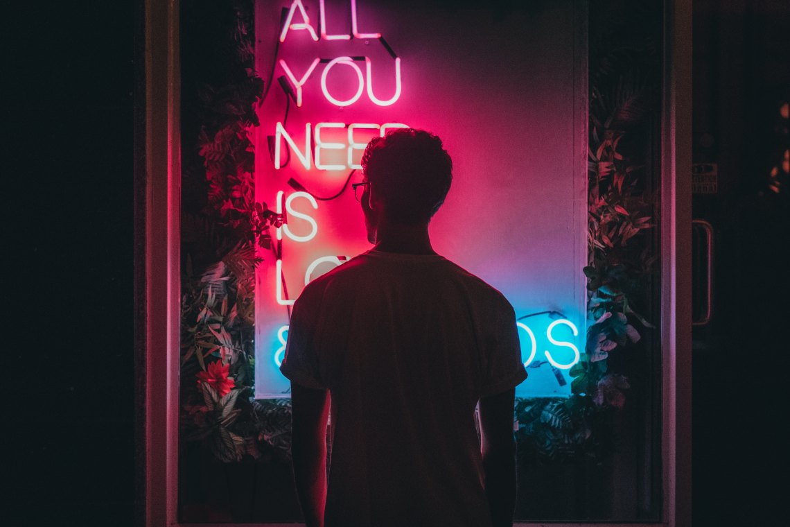 man staring at lighted sign, how to not lose yourself, love and relationships