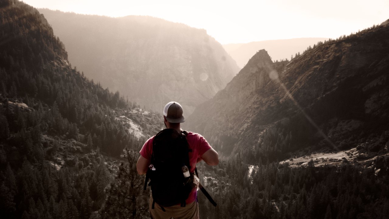 Man hikes in the mountains looking adventurous