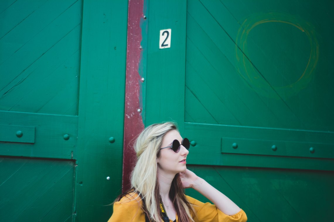 Blonde woman in front of blue door