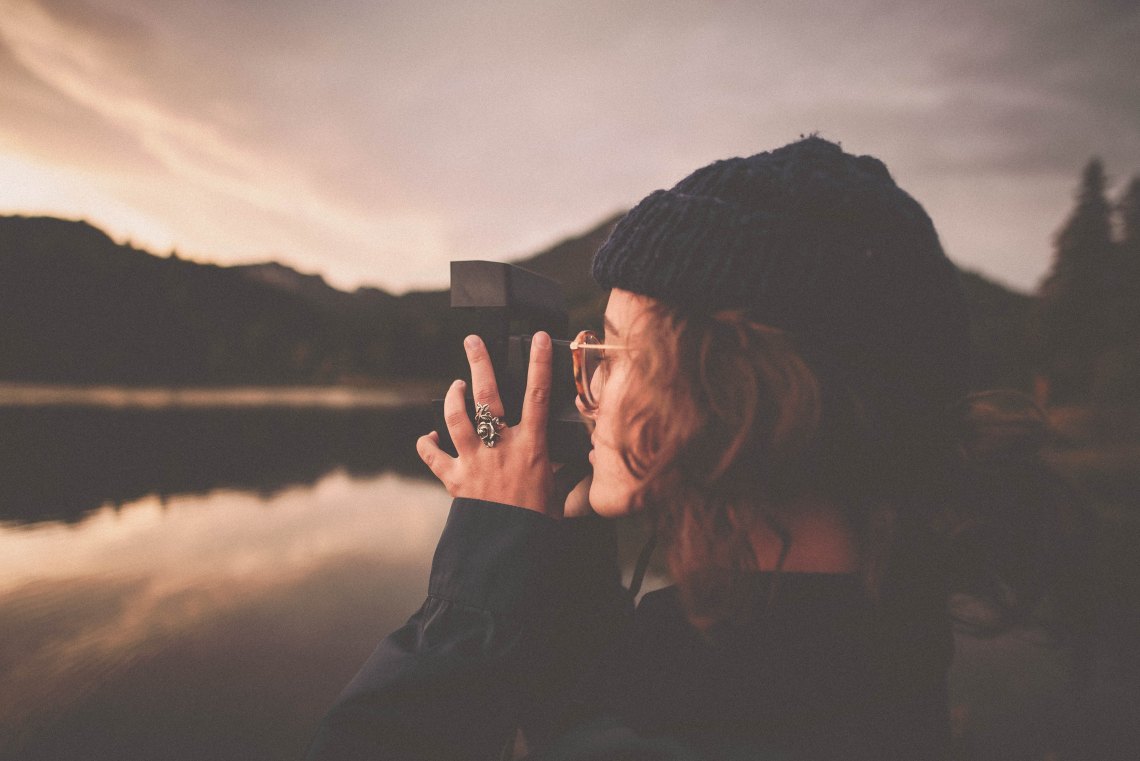 Female photographer looking over lake