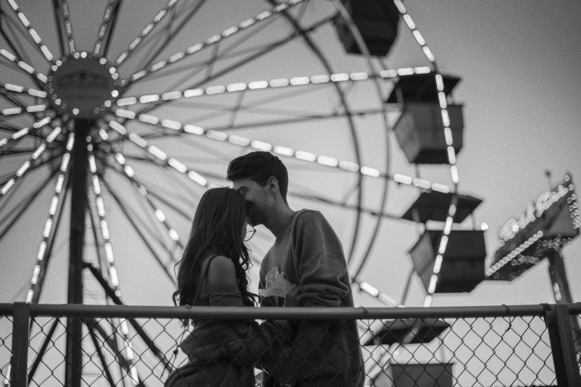 couple in front of a ferris wheel