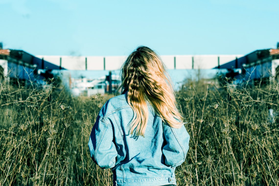 Woman wearing jean jacket in field