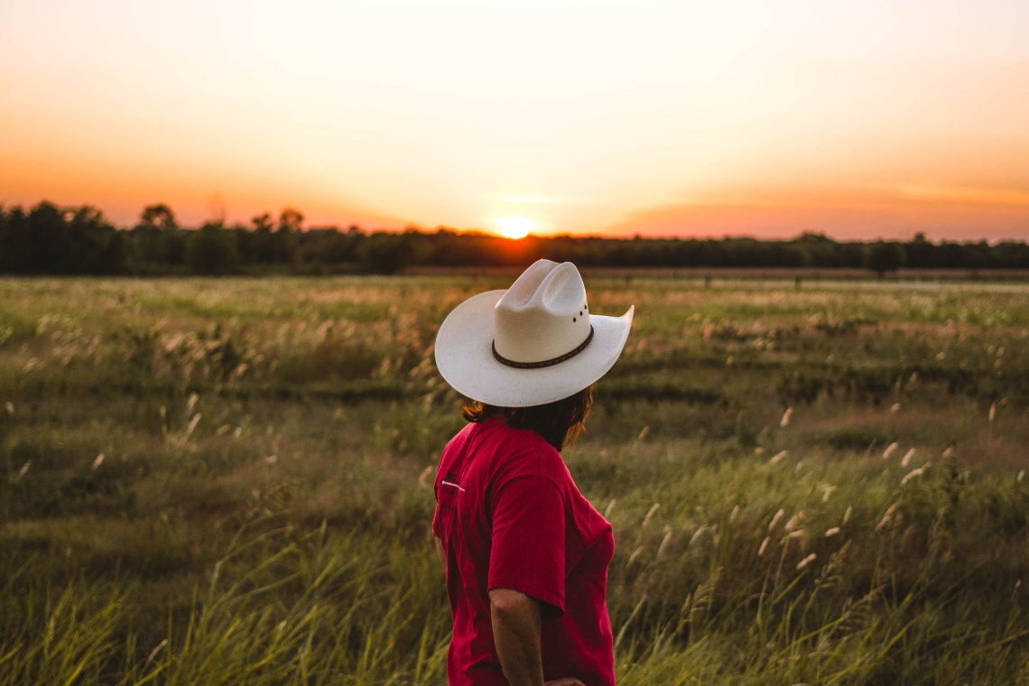 cowgirl in field, country artists you need to listen to