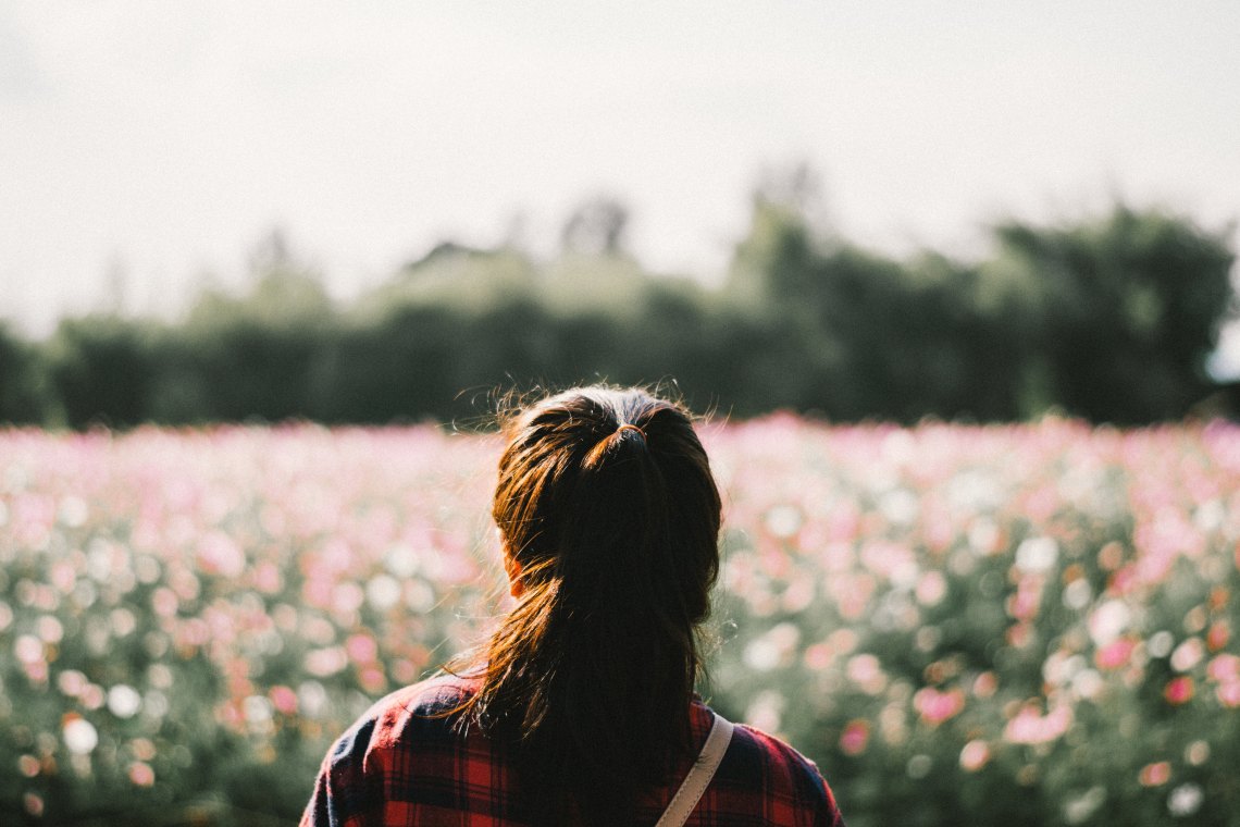 girl in a field hair smiling