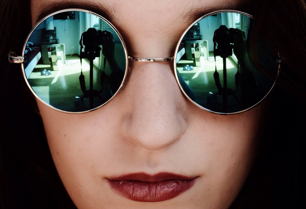 Cool young woman taking selfie with red lipstick and sunglasses