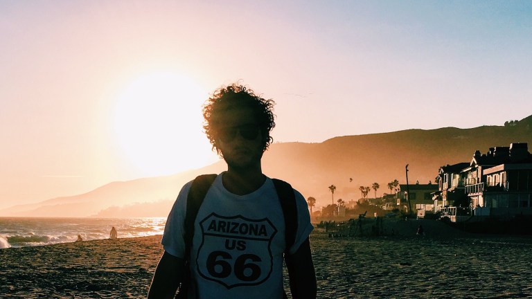 guy in route 66 arizona t-shirt in the summer sunset on the beach