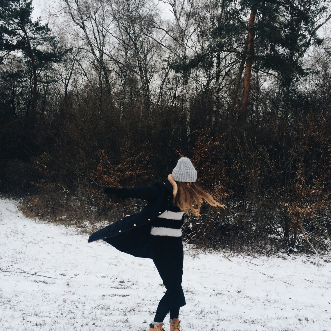 Frolicking in the snow, girl running down a snowy hill in winter