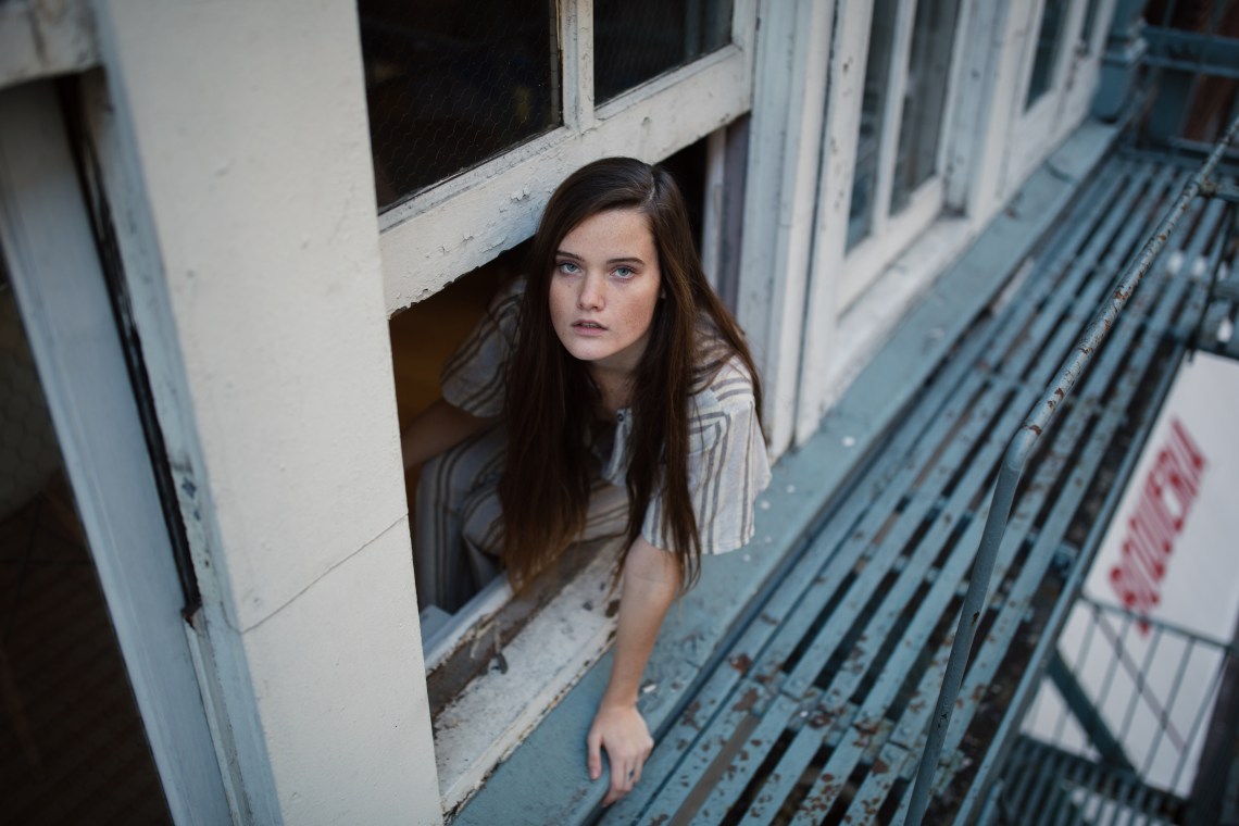 woman climbing through window