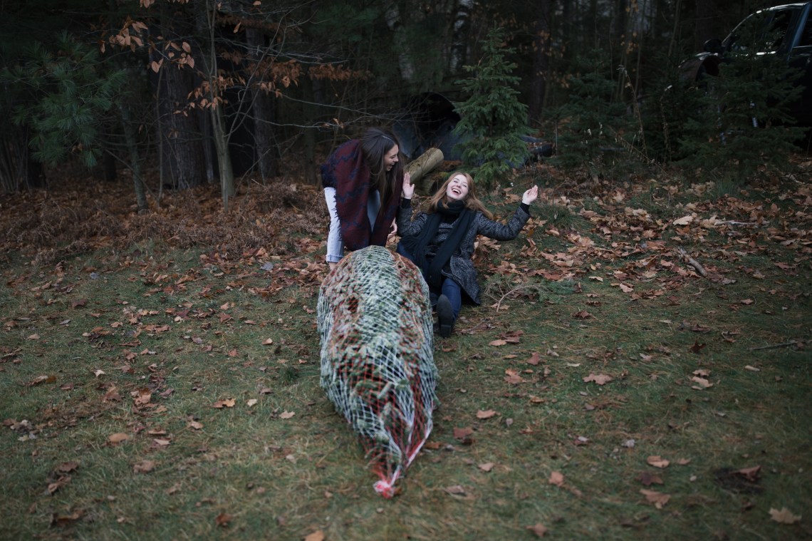 friends laughing with christmas tree