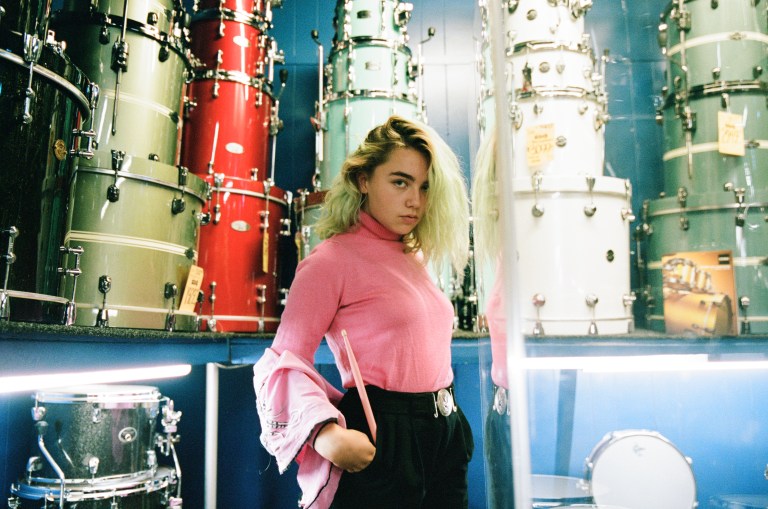 woman standing in front of drums