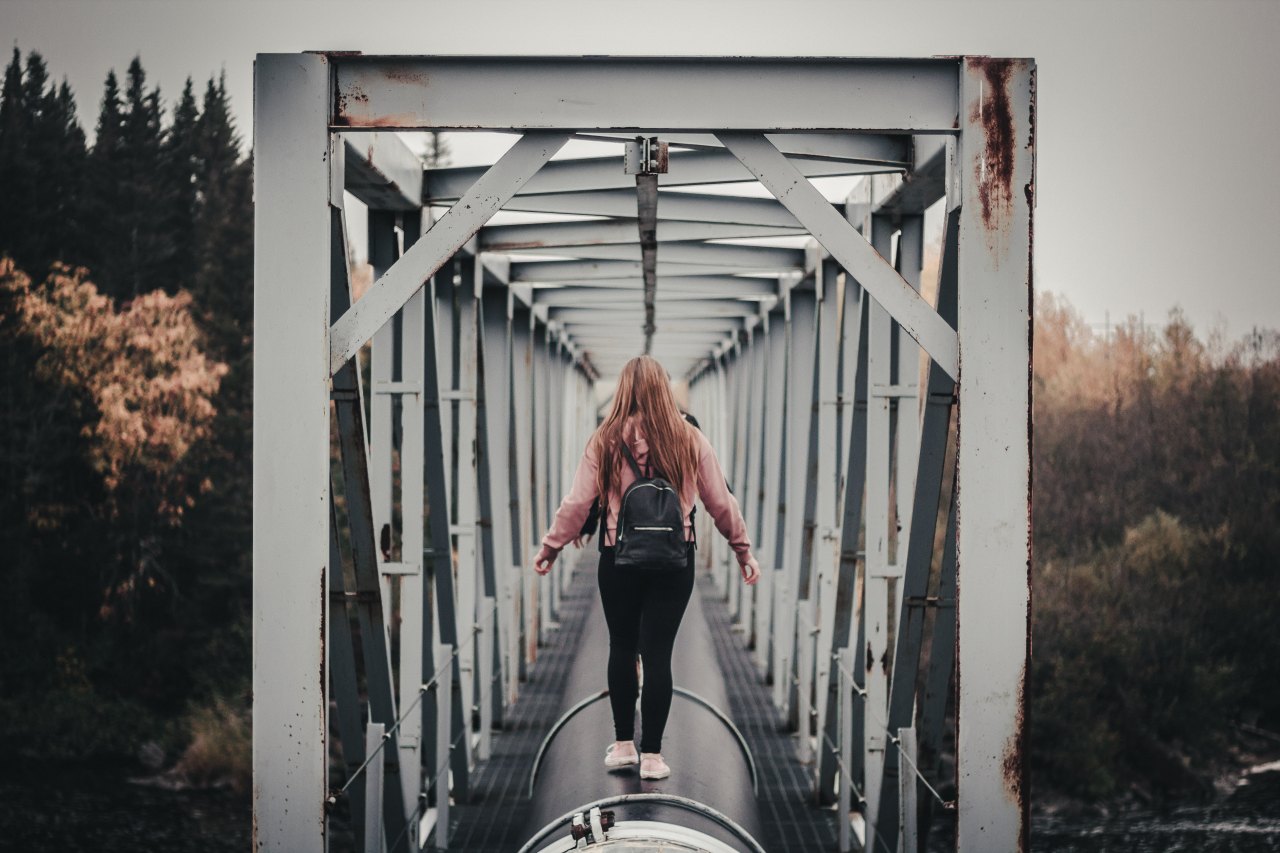 woman walking away on bridge