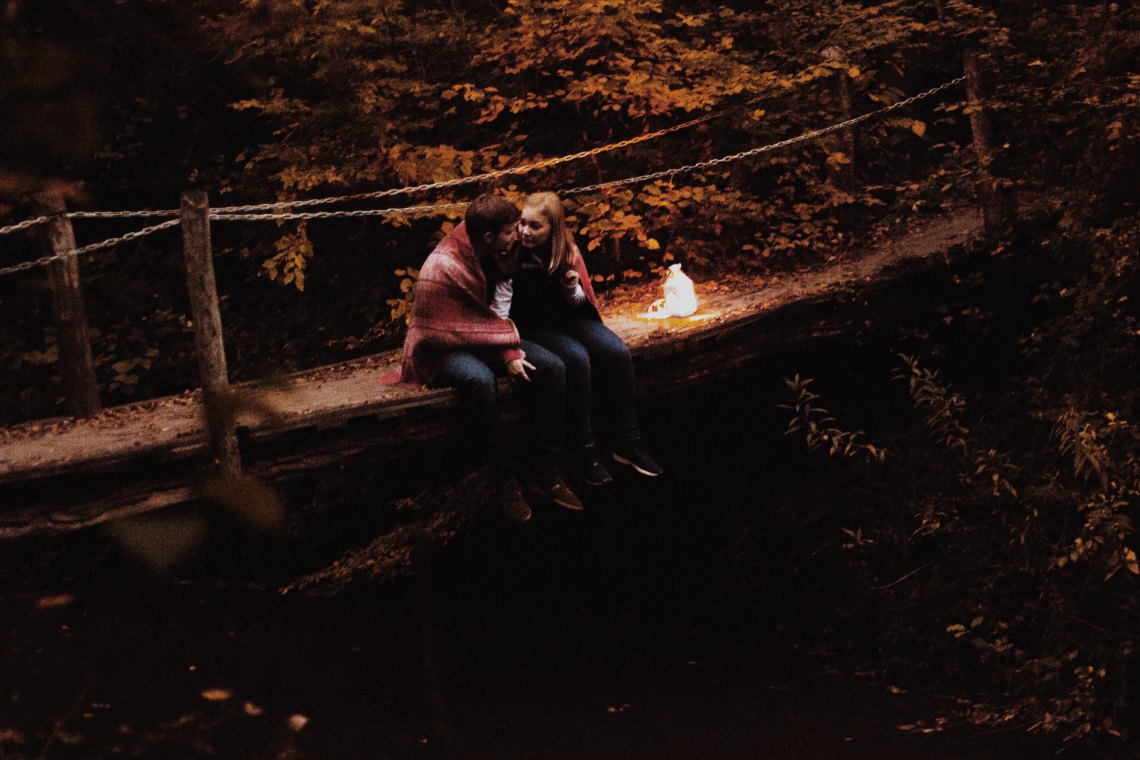 couple sitting together on a bridge