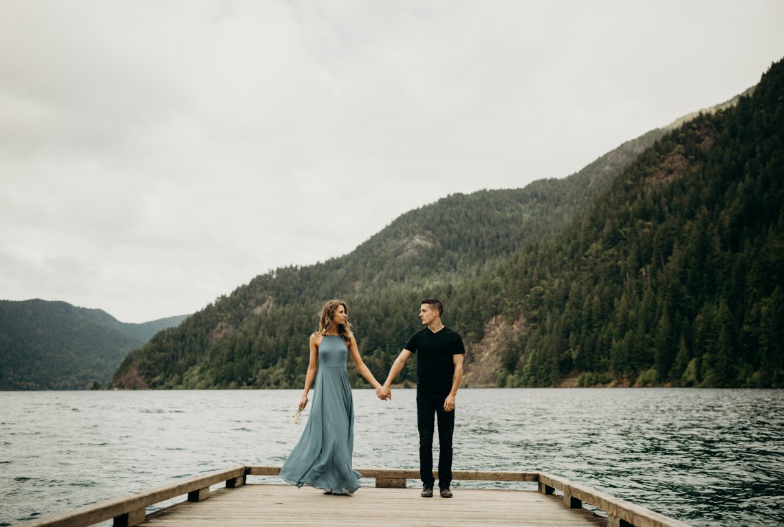 couple on a dock in front of a mountain