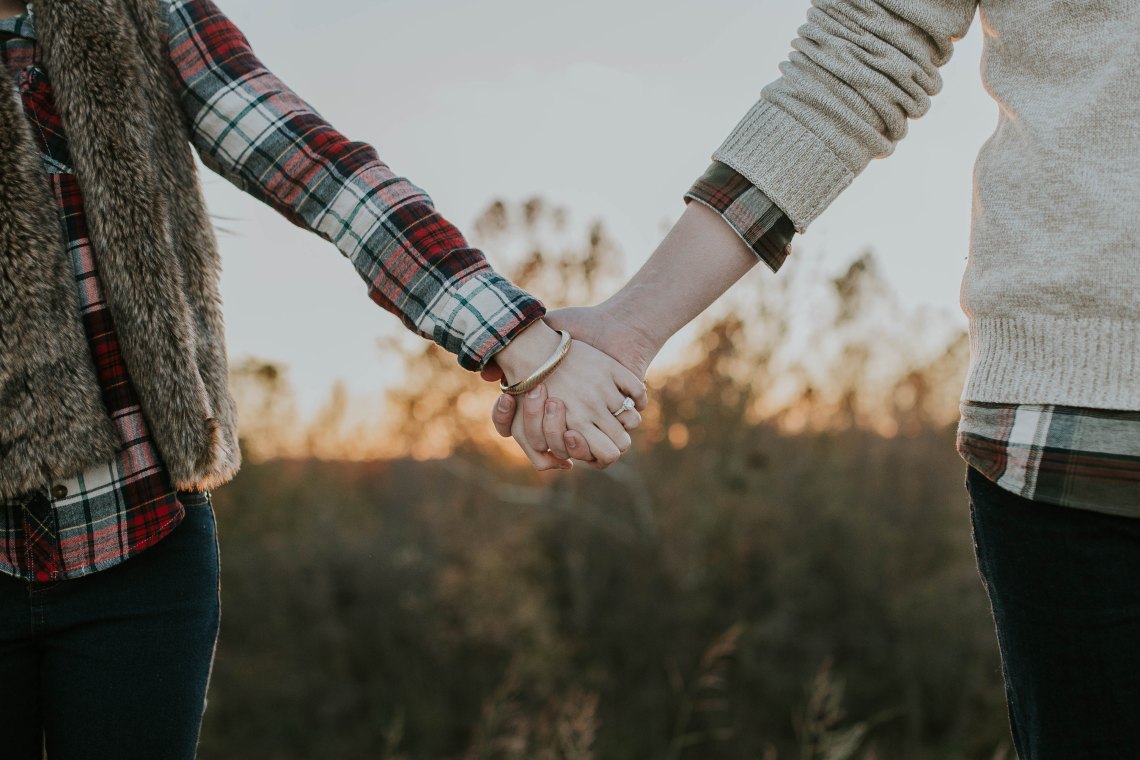 couple holding hands at sunset