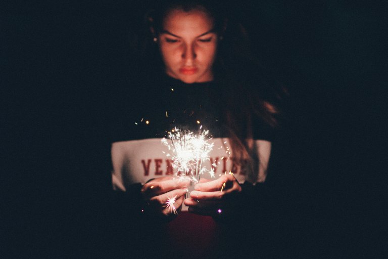 girl in a sweater with a sparkler