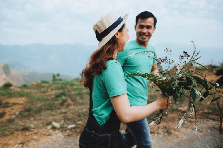 couple walking happily with flowers