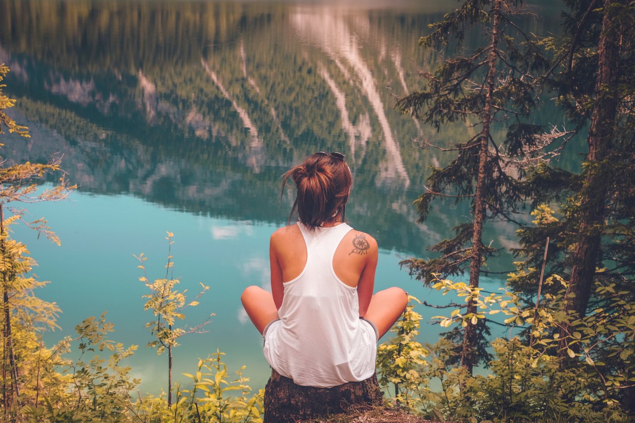 woman sitting on a log contemplating life