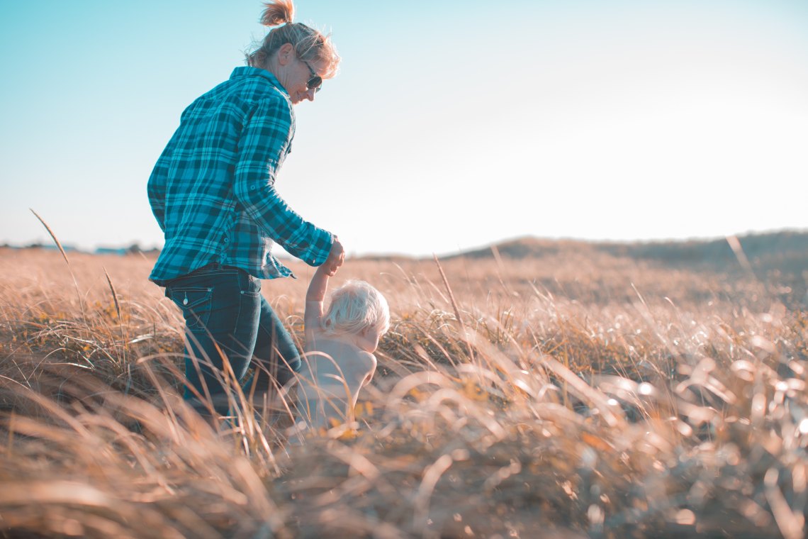 Mom and kiddo running through a wheat field 