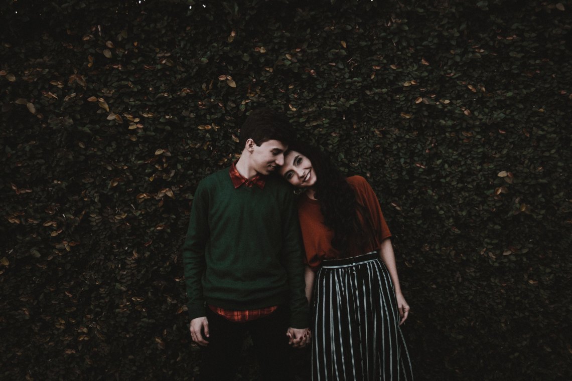 Couple holding hands in greenery