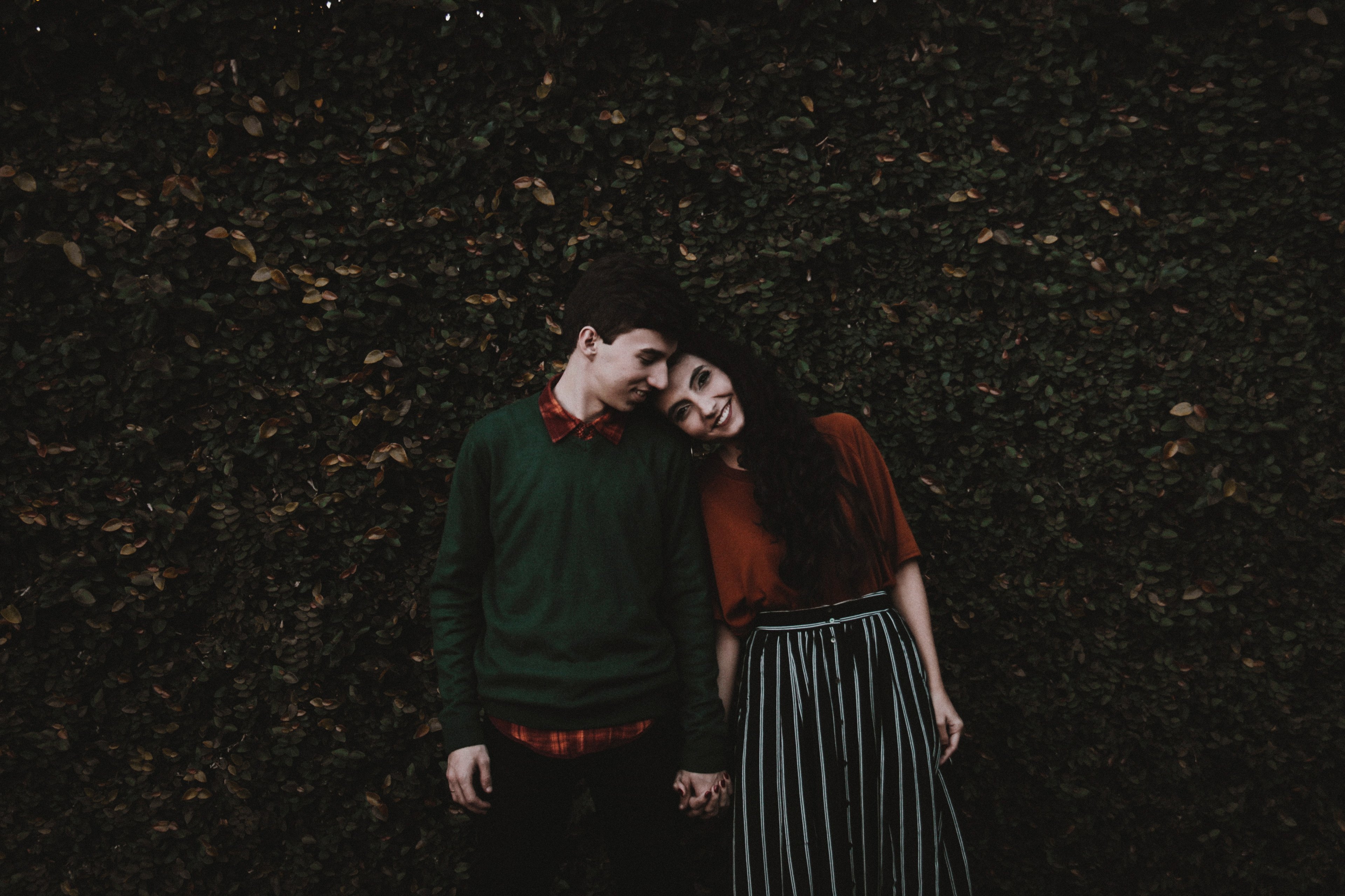 Couple holding hands in greenery