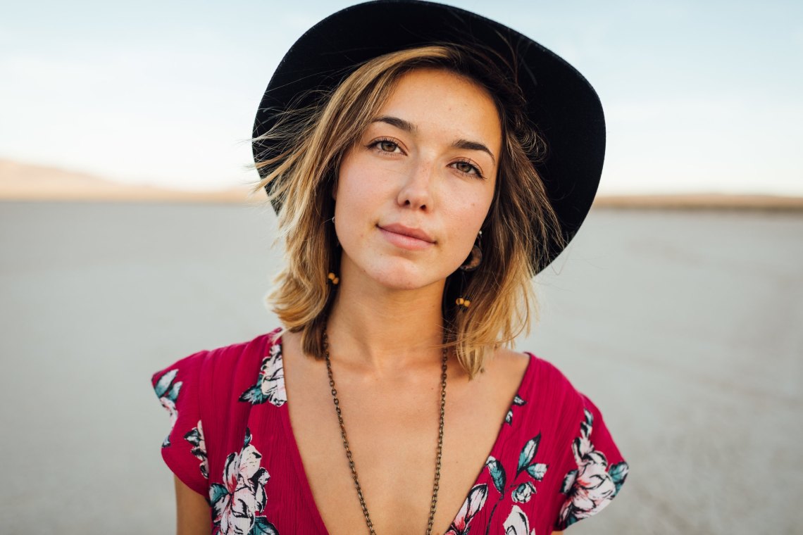 girl stares into the camera in a hat