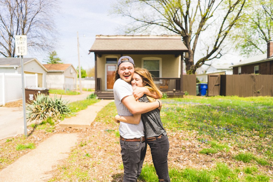 couple hugging in front of their home