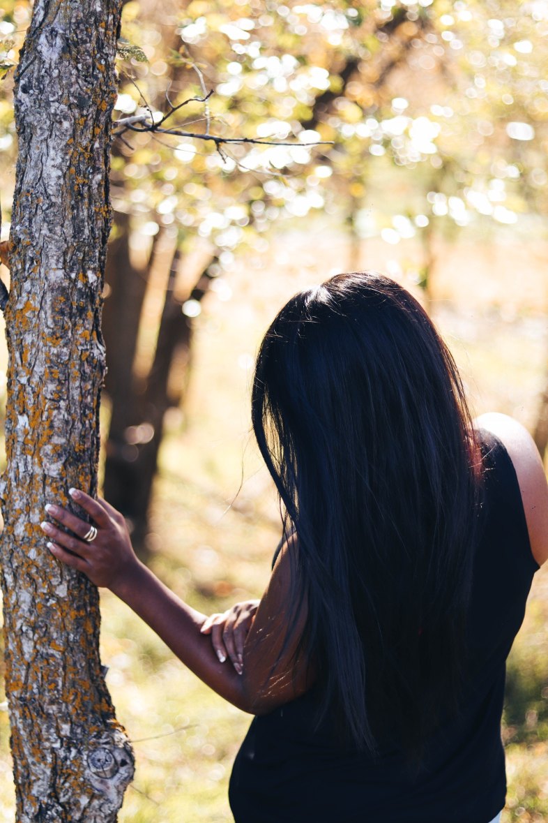 girl standing next to a tree